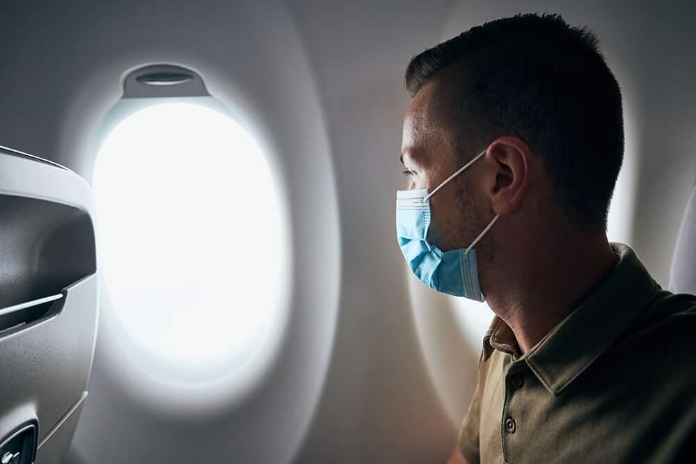 Man on plane wearing face mask