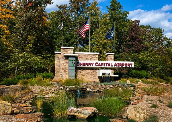 TVC airport entrance sign, pond and flags